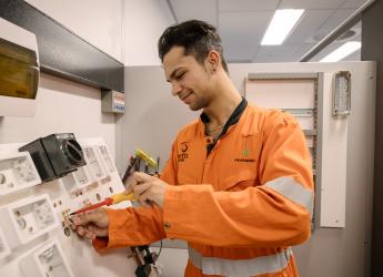 An electrical engineering technician, installing a system on a board.