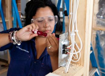 A female electrician, installing an electrical control system.