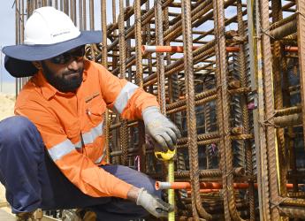 A structural steel worker, measuring steel beams. 
