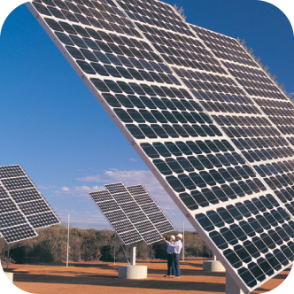 Two solar panel fitters, walk through a large scale solar panel farm. 